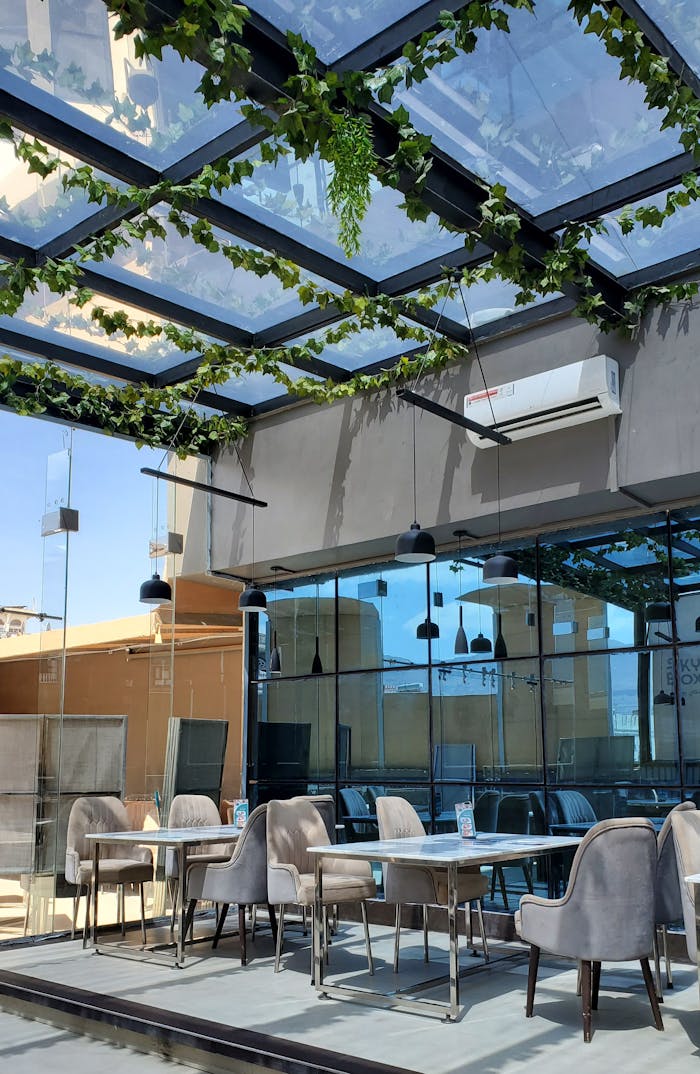Stylish rooftop cafe in Yemen, featuring a glass ceiling adorned with greenery, offering a modern dining experience.