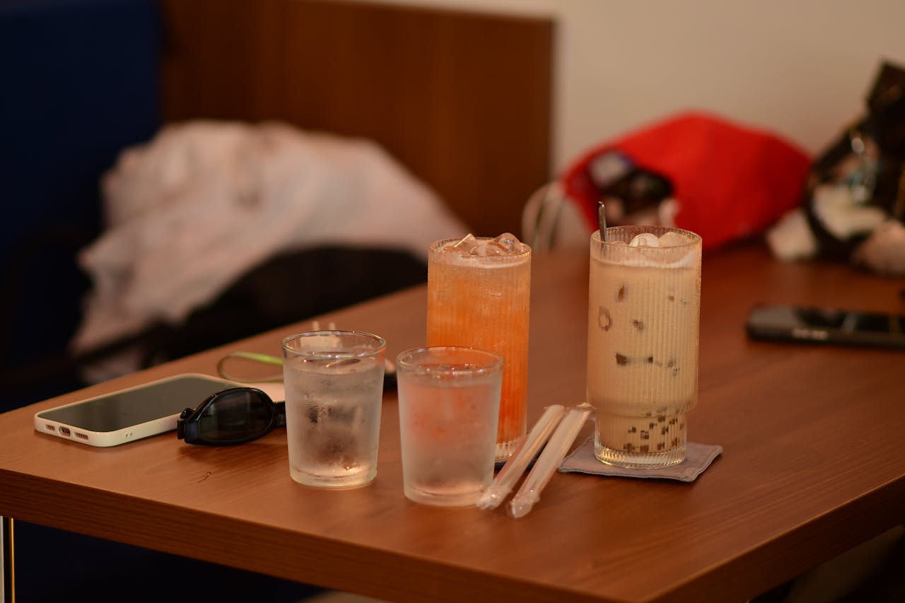 A close-up of assorted drinks and items on a cafe table, capturing a cozy indoor atmosphere.